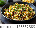 Gourmet pasta dish with savory beef stew, garnished with herbs. 128352385