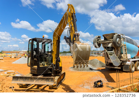 Excavator concrete mixer work together at busy construction site, moving materials on works day 128352736