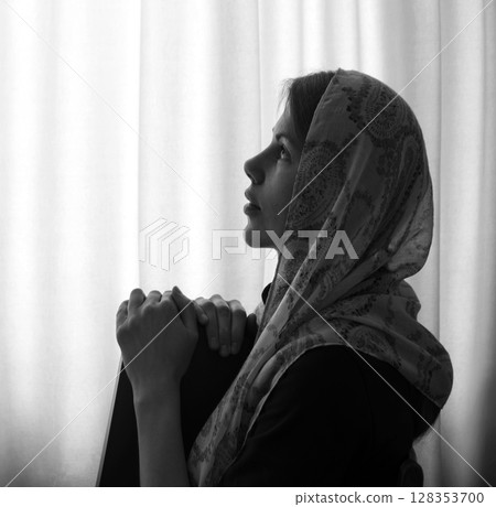 Young girl with bible praying to God 128353700