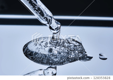 The texture of serum with spicules in a dropper on a blue background. 128353828