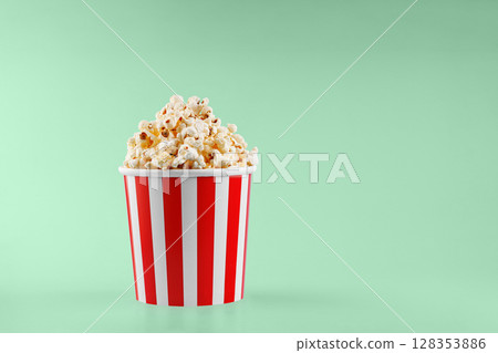 Classic red striped popcorn cardboard cup on Green background Classic red striped popcorn cardboard cup on Green background 128353886