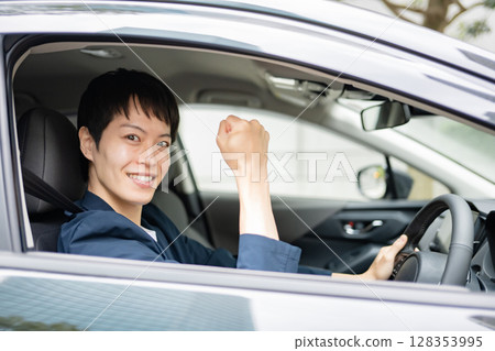 A man in a car posing with his fist in the air 128353995