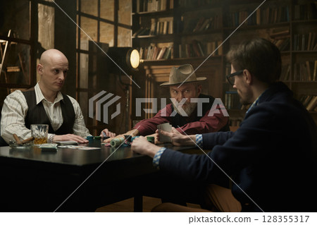 Male company enjoying a table game in a smoky library 128355317