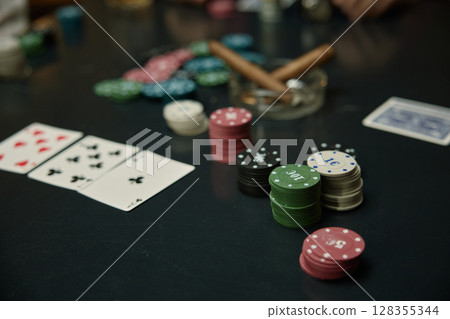Poker night an evening filled with chips, cards, cigars around the Table 128355344