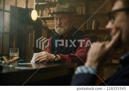 An intense card game between two players in a vintage and timeless setting 128355345