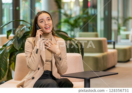 Happy surprised business woman in pleasant conversation phone call good news enjoying talking gossip Happy surprised business woman in pleasant conversation phone call good news enjoying talking gossip 128356731