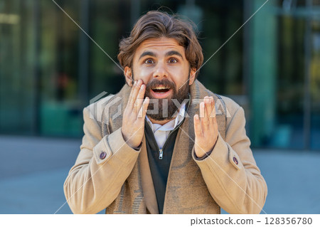 Indian man looking surprised at camera shocked by sudden win good victory news, wow in city street 128356780