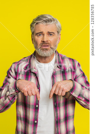 Mature man urging donations, heartfelt plea, pointing down gesture support call, genuine gratitude 128356785