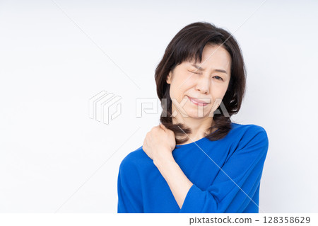 Middle-aged woman with stiff shoulders Middle-aged woman with stiff shoulders 128358629