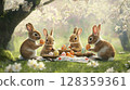 Four adorable rabbits are engaged in an Easter egg celebration in a lush garden. They are sitting on the grass, carefully holding colorful eggs as cherry blossoms surround them. 128359361