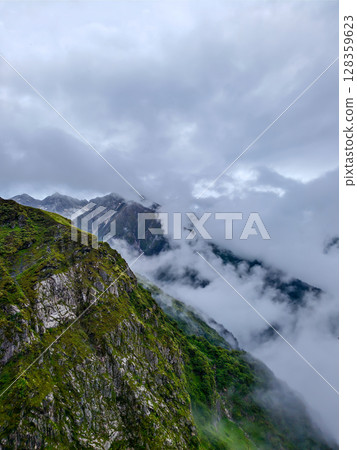 Cloud-Kissed Mountain Valley with Lush Hills 128359623