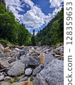 Rocky Forest Stream Bed Under Bright Blue Sky 128359653