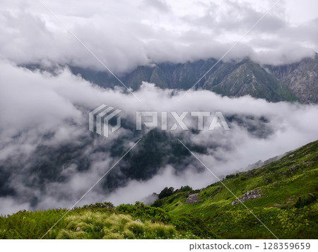 Misty Mountain Landscape with Dramatic Cloud Cover 128359659