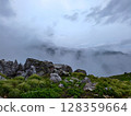 Misty Rocky Mountain Landscape with Grassy Hills 128359664