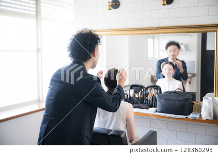 男人和女人,頭髮和化妝,拿著化妝刷,化妝的圖像,看著鏡子 男人和女人,頭髮和化妝,拿著化妝刷,化妝的圖像,看著鏡子 128360293