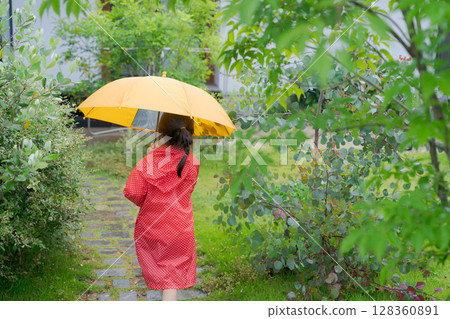 A girl playing with an umbrella on a rainy day A girl playing with an umbrella on a rainy day 128360891