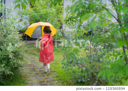 A girl playing with an umbrella on a rainy day A girl playing with an umbrella on a rainy day 128360894