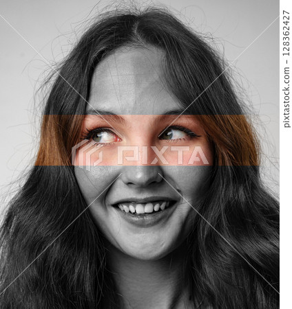 Engaging portrait of a young woman with expressive eyes and a playful smile in a creative art setting 128362427