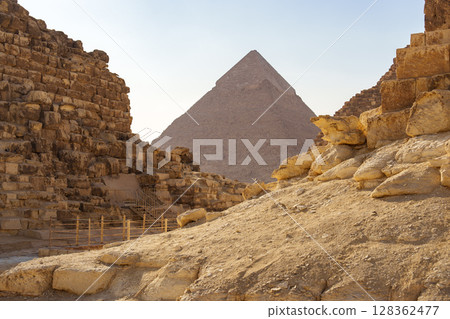 Exploring ancient pyramids at Giza, a glimpse of history amid golden sand under the bright sun 128362477