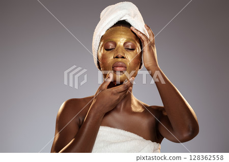 Woman applying gold facial mask at home spa in the evening for skin rejuvenation and relaxation Woman applying gold facial mask at home spa in the evening for skin rejuvenation and relaxation 128362558