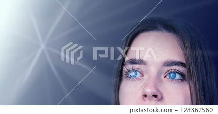 Person with blue eyes gazing thoughtfully into a soft light against a dark background Person with blue eyes gazing thoughtfully into a soft light against a dark background 128362560