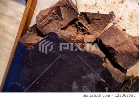 Dark chocolate chunks ready for melting and baking in a kitchen setting during the day 128362583