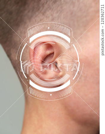 Close-up view of a person's ear with sound wave graphics illustrating hearing concept 128362711