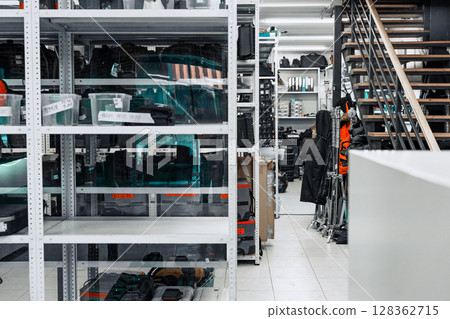 Storage area filled with equipment and tools in a well-organized workshop during daylight hours 128362715