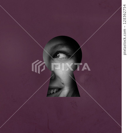 View through a keyhole reveals a smiling face, showcasing curiosity and intrigue in a vibrant setting View through a keyhole reveals a smiling face, showcasing curiosity and intrigue in a vibrant setting 128362754