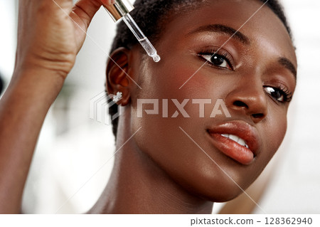 Applying a skincare serum in a bright beauty studio during a morning skincare routine Applying a skincare serum in a bright beauty studio during a morning skincare routine 128362940