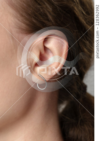 Sound waves and ear anatomy illustrated on a persons ear for educational purposes in a clinical setting 128362992