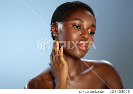 Model poses gracefully with a serene expression against a soft blue background in a studio setting Model poses gracefully with a serene expression against a soft blue background in a studio setting 128363008