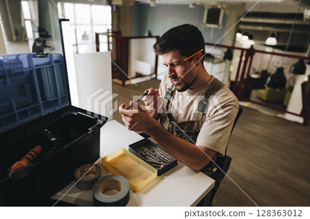 Skilled worker organizes tools while preparing for repairs in a modern office environment 128363012
