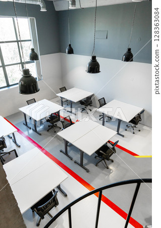 Modern office workspace featuring tables and chairs in a bright, minimalist design Modern office workspace featuring tables and chairs in a bright, minimalist design 128363084