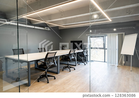 Conference room with modern design and glass walls in a corporate office setting during daylight Conference room with modern design and glass walls in a corporate office setting during daylight 128363086