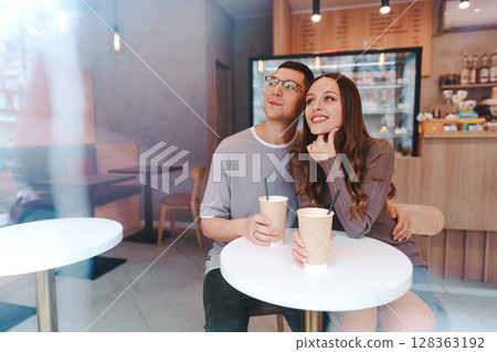 Young couple enjoying coffee in a cozy cafe on a relaxed afternoon in the city 128363192