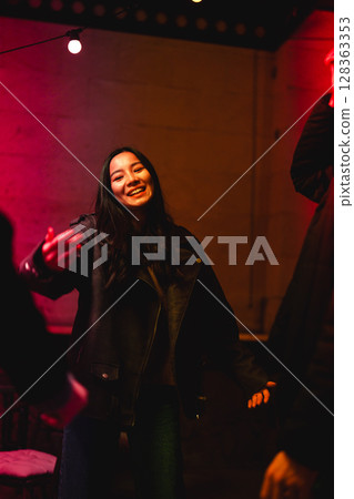 Joyful celebration with friends in a vibrant setting during a night out Joyful celebration with friends in a vibrant setting during a night out 128363353