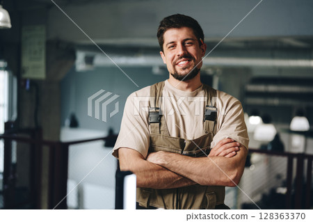 Skilled worker operating power tools in workshop setting during afternoon hours Skilled worker operating power tools in workshop setting during afternoon hours 128363370