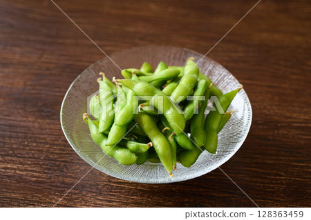 Boiled edamame beans served on a glass plate Boiled edamame beans served on a glass plate 128363459