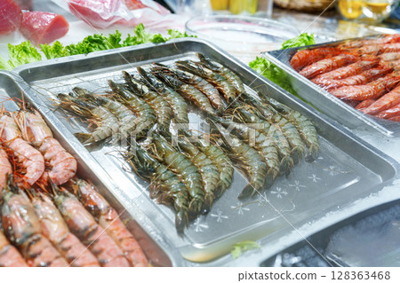 Fresh seafood displayed at a market stall during midday in a coastal town 128363468
