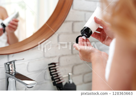 Skincare routine in a modern bathroom during morning preparations for a fresh start to the day 128363663