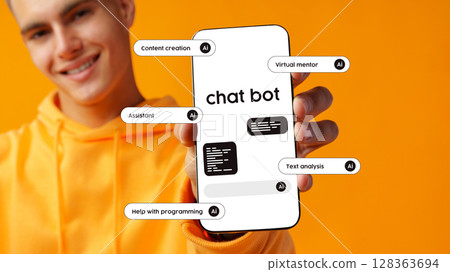 Young man showcases chatbot features on smartphone with vibrant orange background Young man showcases chatbot features on smartphone with vibrant orange background 128363694