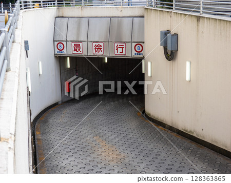 地下停車場入口處的坡道和「減速帶」標誌 128363865