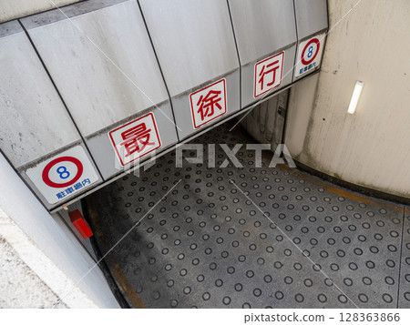 地下停車場入口處的坡道和「減速帶」標誌 128363866