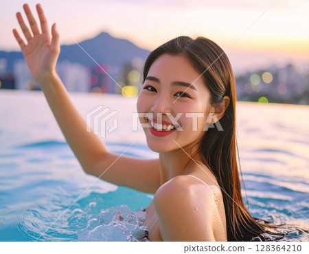 Young woman waving on the beach 128364210