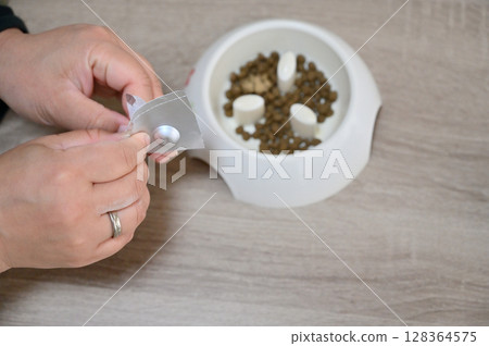 Topping dog food with green-lipped mussel supplements and preventative medicine (for fleas, ticks, and heartworms) 128364575