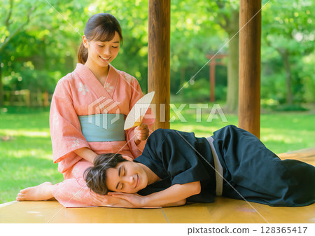 一對情侶在大自然中互相依偎在對方的腿上 128365417