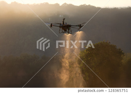 Agricultural Drone Spraying pesticides to increase productivity and destroys harmful insects. Agricultural Drone Spraying pesticides to increase productivity and destroys harmful insects. 128365751