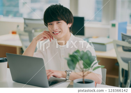 Young man doing desk work Young man doing desk work 128366142