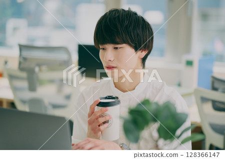 Young man doing desk work Young man doing desk work 128366147